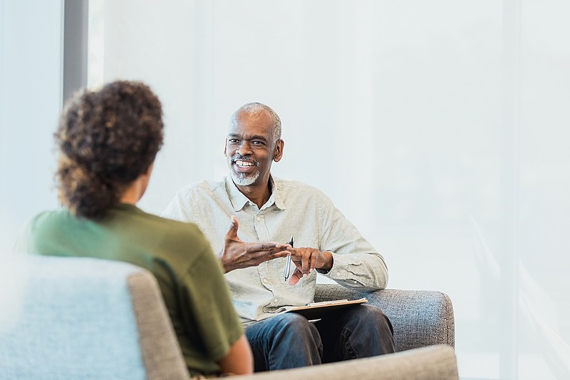 An image of a man and a woman sitting and engaged in conversation, where the man is putting his coaching skills to work guiding the woman.